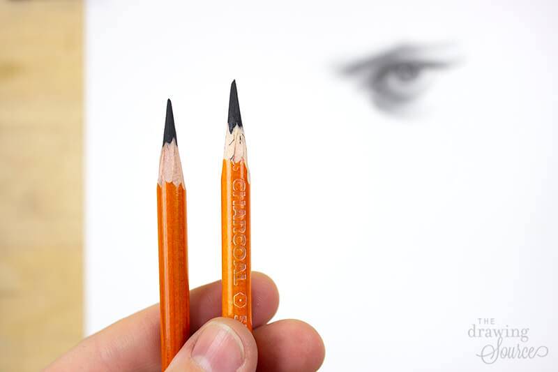 Two Generals charcoal pencils in front of a realistic eye drawing